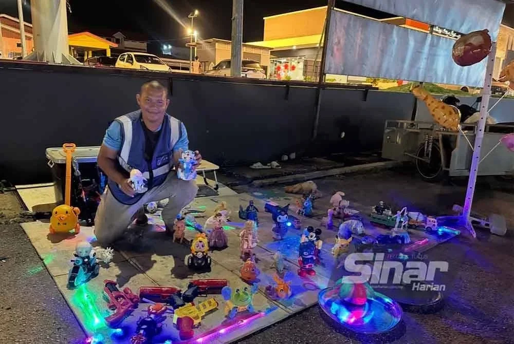 Mohd Aminuddin menunjukkan barangan mainan jualannya. FOTO SINAR HARIAN - ADILA SHARINNI WAHID