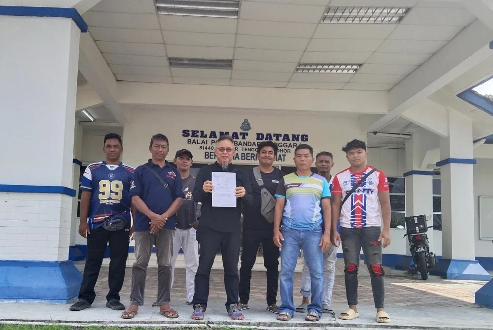 Jasni Amat (tengah) bersama penduduk Kampung Sayong Pinang menunjukkan laporan polis berkaitan pencemaran sungai Sayong di Kota Tinggi di Balai Polis Bandar Tenggara.