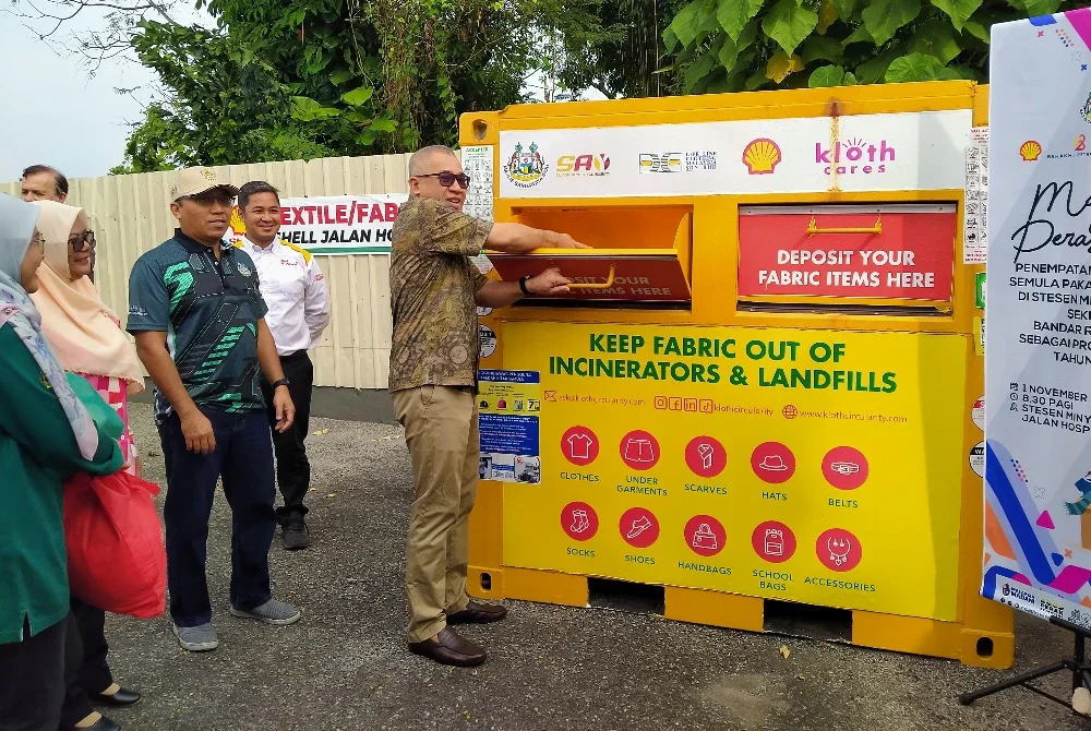 Zamakhshari (kanan) menyempurnakan Majlis Perasmian Penempatan Tong Kitar Semula Pakaian Terpakai di Shell Jalan Hospital pada Sabtu.
