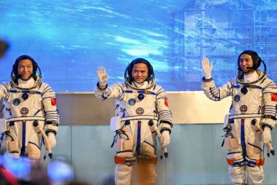 Angkasawan misi angkasa China Shenzhou-21, Zhang Hongzhang (kiri), Komander Zhang Lu (tengah) dan Wu Fei (kanan), melambaikan tangan semasa upacara pelepasan sebelum berangkat menaiki bas menuju ke kapal angkasa Shenzhou-21 di Pusat Pelancaran Satelit Jiuquan, Gurun Gobi, barat laut China. -AFP