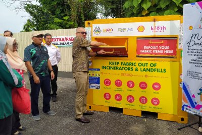 Zamakhshari (kanan) menyempurnakan Majlis Perasmian Penempatan Tong Kitar Semula Pakaian Terpakai di Shell Jalan Hospital pada Sabtu.