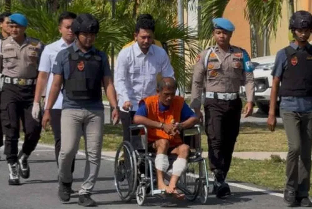 Suspek ketika dibawa ke balai untuk tujuan sidang media. - Foto: Agensi