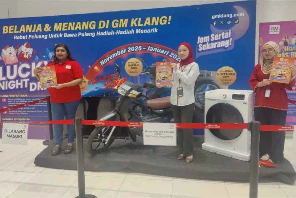 Nurul Syazana (tengah) menunjukkan kempen ‘Lucky Night Draw’ yang diperkenalkan sempena pelancaran waktu operasi baharu pusat borong berkenaan.