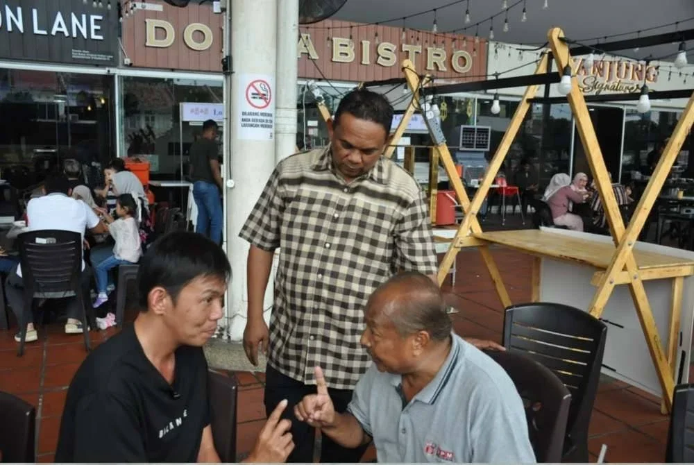 Danny Khoo (kiri) mengucap syahadah yang dipimpin oleh seorang sukarelawan IKUT sambil diperhatikan oleh Zolkifly Md. Lazim (berdiri, tengah) di George Town, Pulau Pinang.