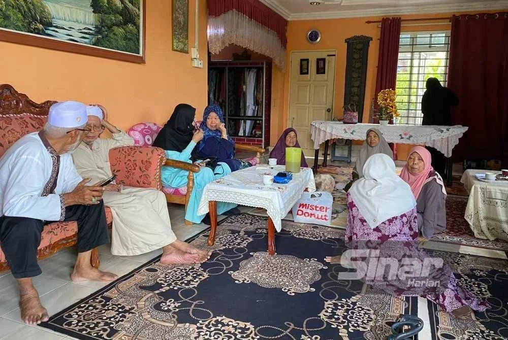 Zaiton (kanan) menerima ziarah daripada sanak saudara di rumahnya di Kampung Kepas Apam, Pasir Mas pada Ahad. Foto: SINAR HARIAN/HAZELEN LIANA KAMARUDIN