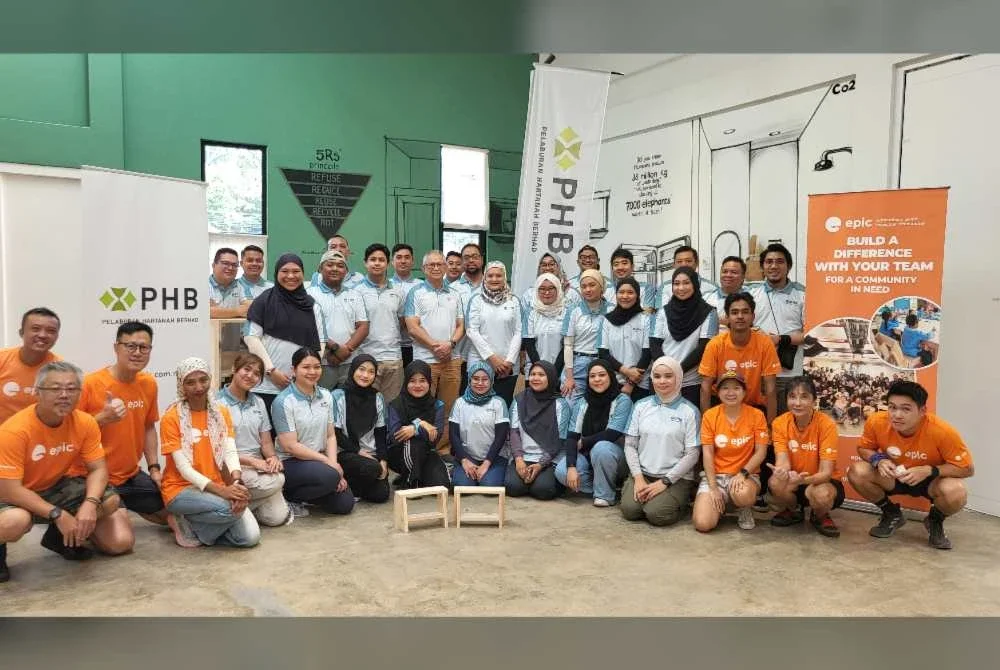 Mohamad Damshal (berdiri, lapan dari kanan) bergambar bersama warga kerja PHB dan EPIC Homes dalam program ‘The Good Builder’ di PARC, Taman Subang Ria pada Ahad.