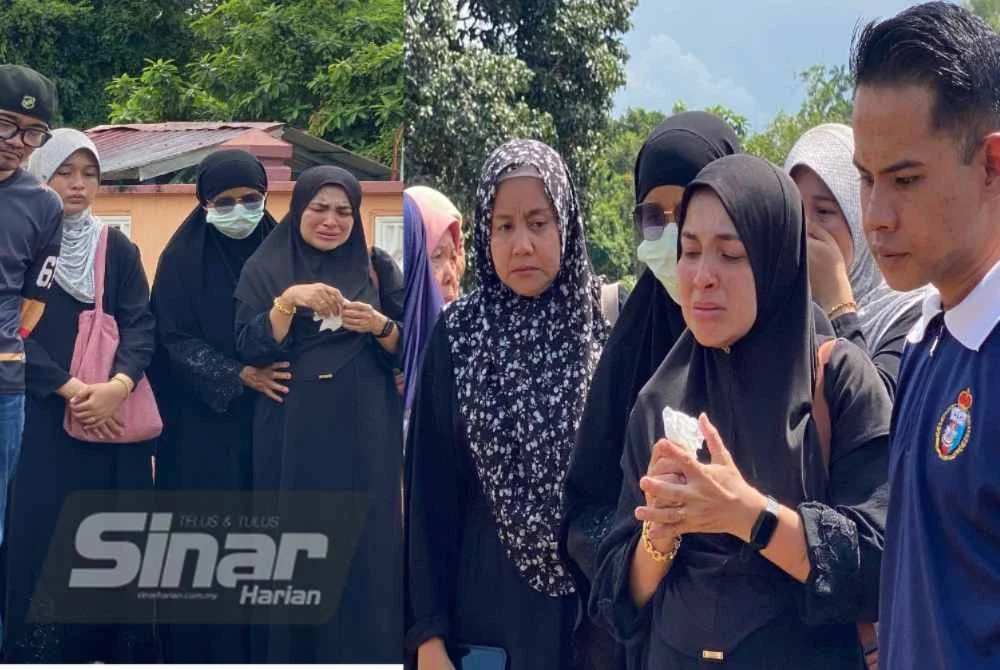 Wan Fatihah (dua dari kanan) tidak dapat menahan sebak semasa pengebumian suaminya di Tanah Perkuburan Islam, Kampung Apam, Apam Putra, Pasir Mas pada Ahad.