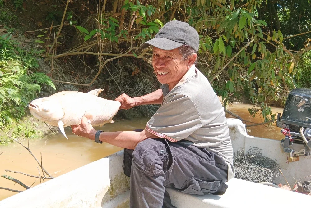 Majid menunjukkan ikan sungai yang mati akibat pencemaran yang berlaku di hulu Sungai Johor.