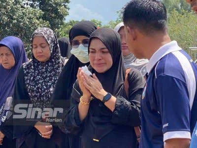 Wan Fatihah (dua dari kanan) tidak dapat menahan sebak semasa pengebumian suaminya di Tanah Perkuburan Islam, Kampung Apam, Apam Putra, Pasir Mas pada Ahad.