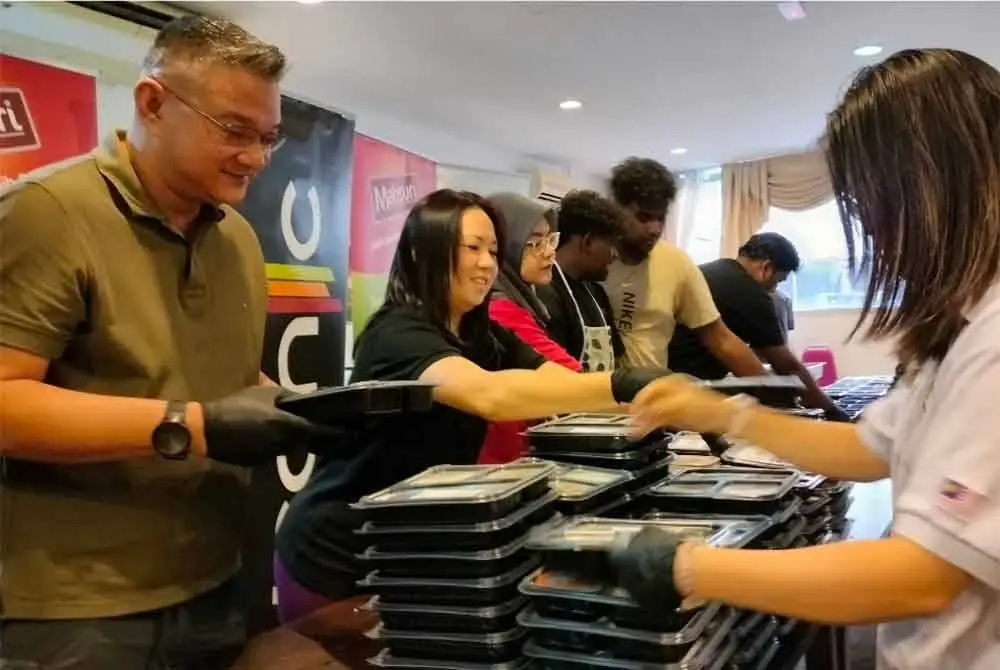 Pelajar kulinari Kolej SEGi Pulau Pinang menyediakan pek makanan sempena program Spread the Love Bento 3.0 - Share a Meal, Share the Love!.