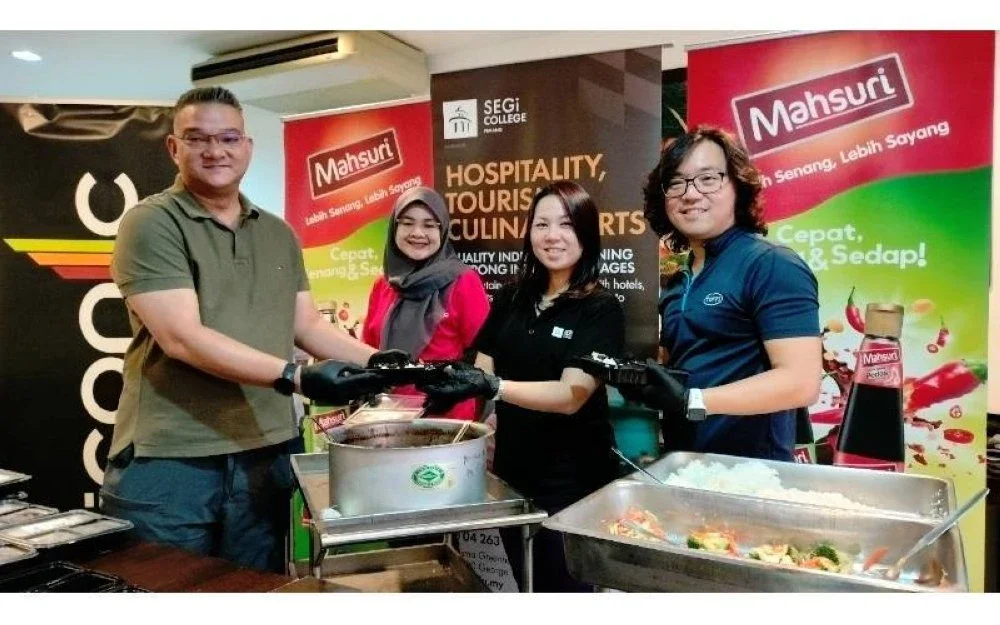 
Pengarah Hal Ehwal Luar Mahsuri Dagang Sdn Bhd, Mohd Jazri Ikmal Hijaz (kiri) bersama, Pengetua Kolej SEGi Pulau Pinang, Dr Leong Mi-Chelle (dua, kanan) menunjukkan kotak bento yang diagihkan kepada empat rumah kebajikan sekitar George Town, pada  Ahad