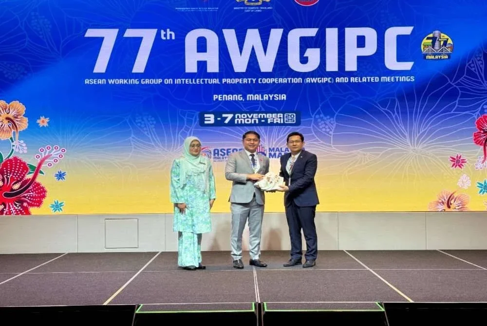 Yusnieza Syarmila dan Riduan (tengah) menyampaikan cenderahati kepada Pengerusi AWGIPC, Suon Vichea.