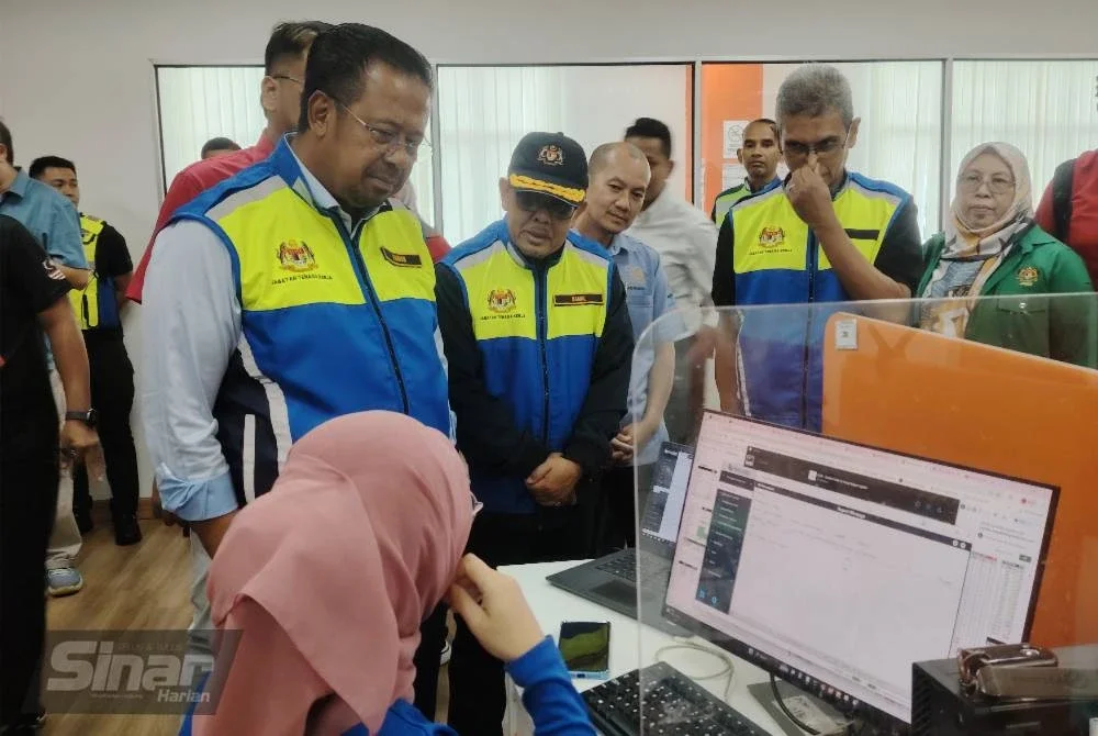 Abdul Rahman (kiri) meninjau proses kerja di sebuah gudang logistik di Pulau Indah, Klang pada Selasa.
