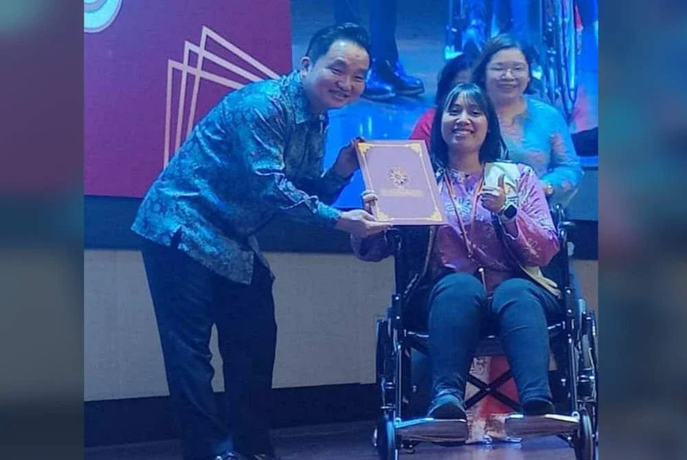 Suee Lim menyampaikan sijil kepada salah seorang penerima pada Majlis Graduasi Komuniti Setempat Selangor pada Selasa.