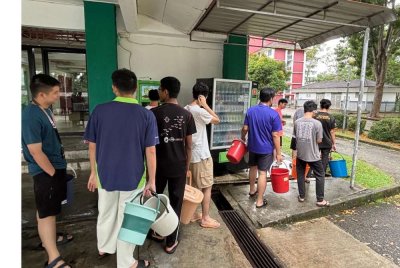 Sebahagian pelajar UTM beratur bagi mengambil air bersih dari lori Ranhill SAJ.