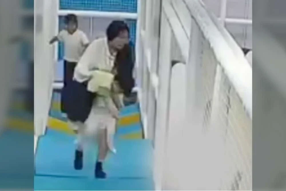 Seorang wanita cuba menyelamatkan anaknya yang tercekik boba semasa bermain trampolin di di Zhejiang, China. Foto Agensi