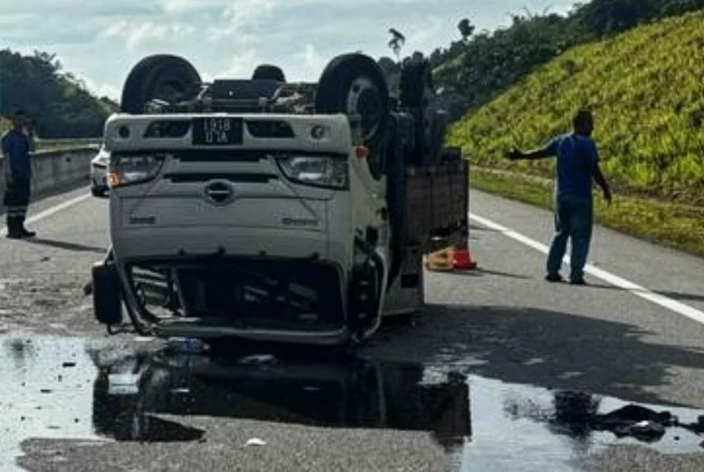 Lori terbalik menyebabkan pertumpahan minyak di tempat kejadian. Foto ihsan PDRM