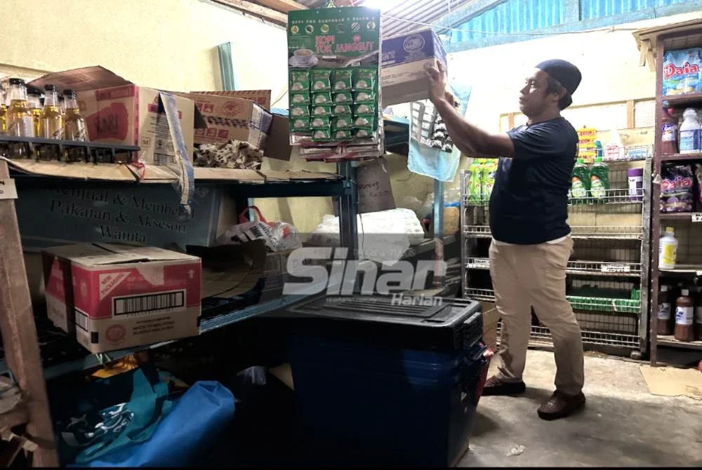 Mohd Husin mengalihkan barangan ke tempat tinggi. 