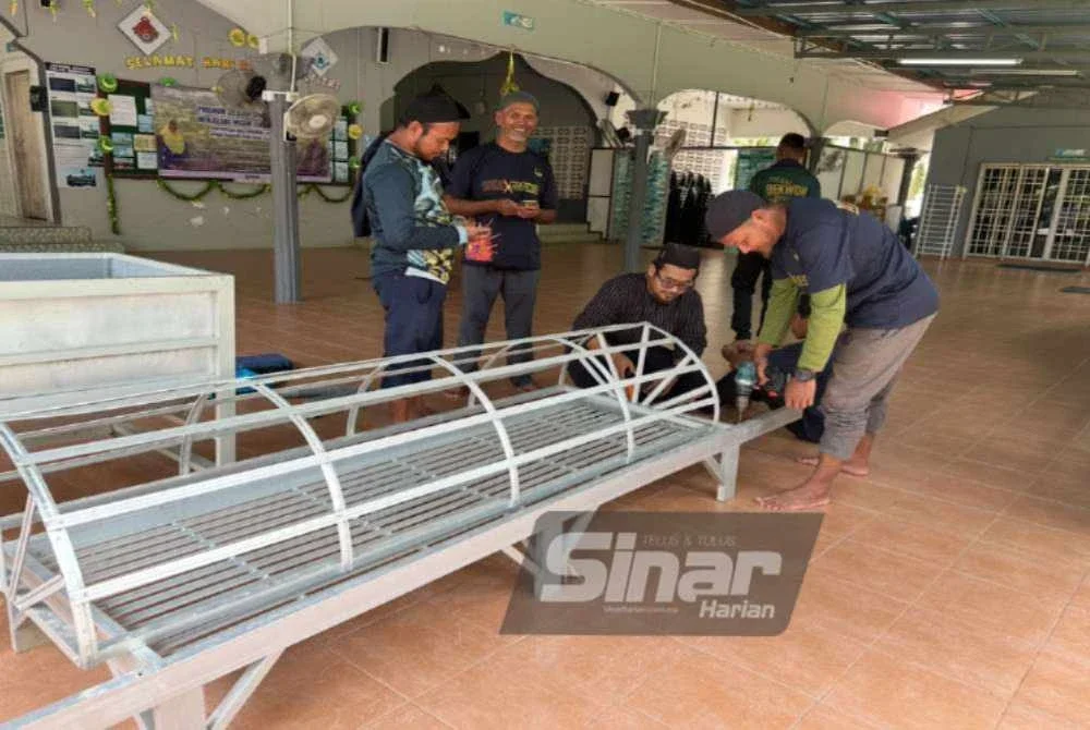 Penduduk bergotong-royong membaiki pengusung jenazah bagi persediaan kematian semasa banjir.
