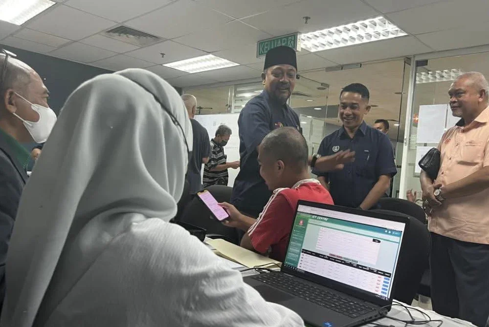 Abdul Gafar (tiga dari kanan) dan Muhammad Amri (dua dari kanan) meluangkan masa berjumpa penduduk yang hadir ke Bilik Gerakan Penilaian Cukai Taksiran MBAS pada Rabu. Foto MBAS