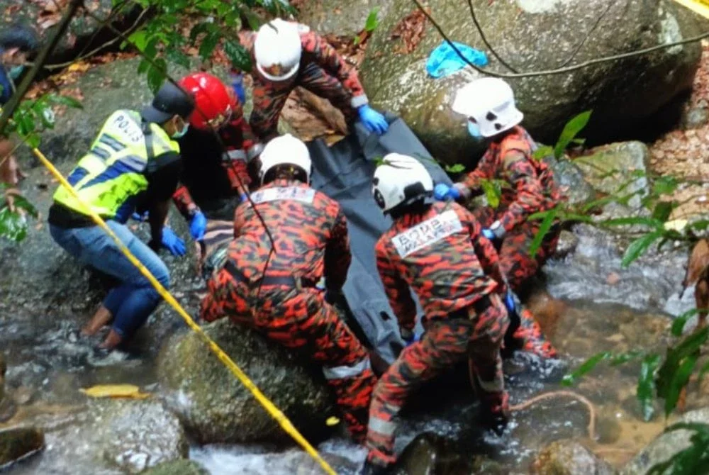 Anggota bomba mengangkat keluar mangsa dari sungai sebelum diserahkan kepada polis untuk tindakan lanjut. Foto: JBPM Perak 
