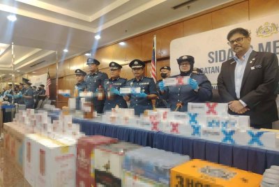 Wan Norizan (dua dari kanan) menunjukkan rampasan rokok dan minuman keras hasil serbuan dua gudang persendirian di Lembah Klang. 