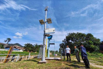 Chan Kuang ditemani Rohushsyifa melihat salah satu siren yang dipasang di Kampung Galing selepas menghadiri Taklimat PRAB di Perkarangan Surau Kampung Galing di sini pada Rabu. Foto Sinar Harian