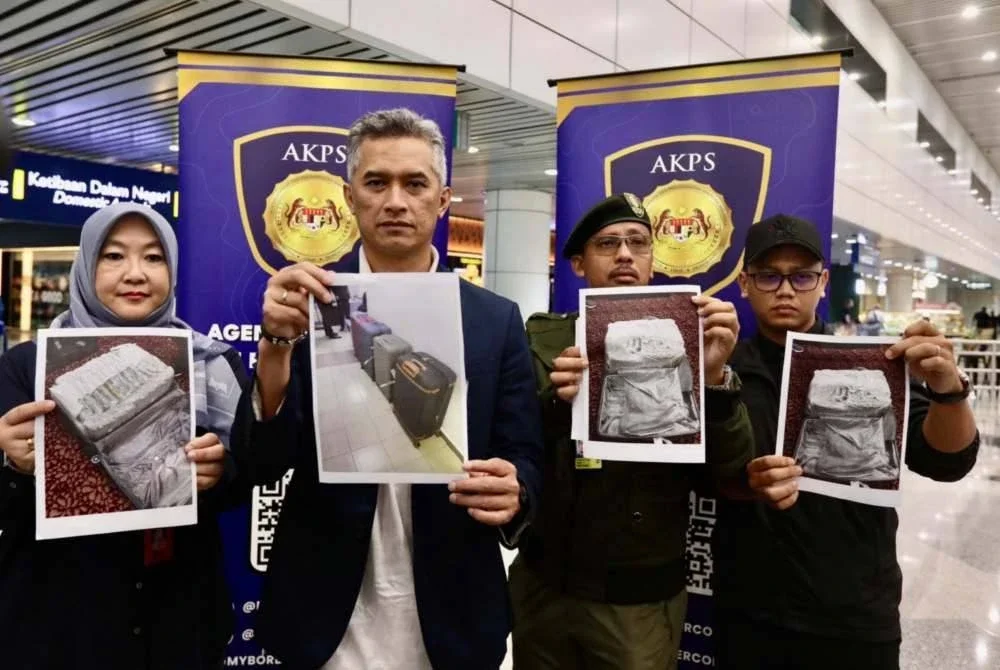 Mohd Shuhaily (dua kiri) menunjukkan dadah yang dirampas.