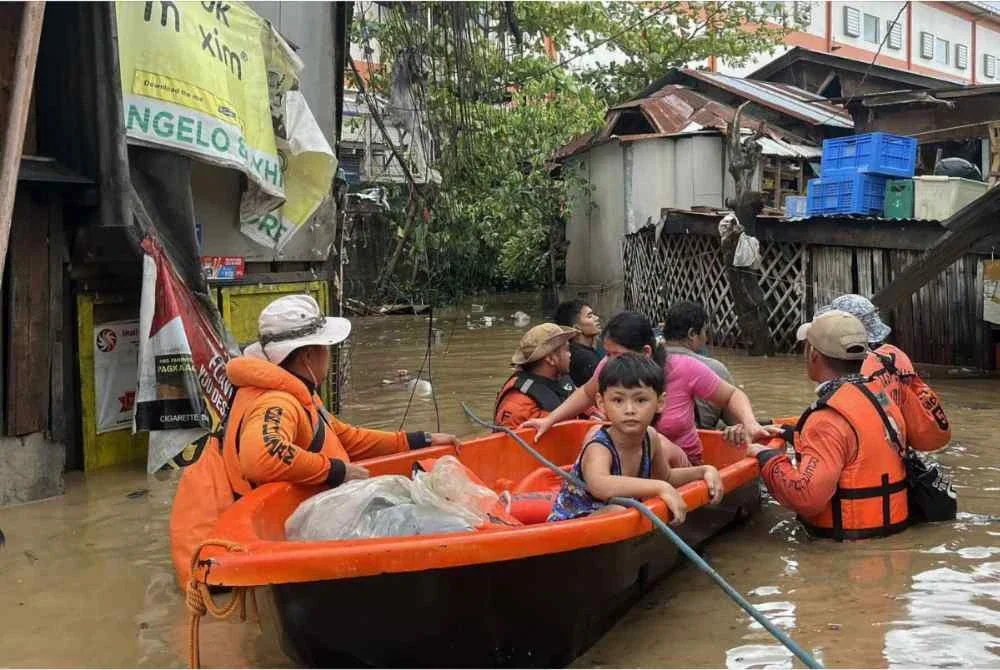 Anggota Pengawal Pantai Filipina memindahkan penduduk dari rumah yang dibanjiri di Cebu susulan hujan lebat akibat Taufan Kalmaegi. - AFP