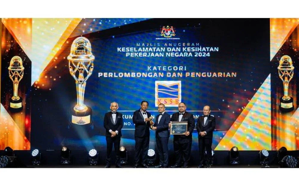 Mohd Bazli (tengah) bersama-sama dengan Ketua Jabatan Kesihatan, Keselamatan dan Persekitaran KSSB, Nadzli Ahayalimuddin menerima Anugerah Majlis Negara bagi Keselamatan dan Kesihatan Pekerjaan (NCOSH) 2024 bagi kategori Perlombongan dan Penguarian daripada Abdul Rahman (dua dari kiri).