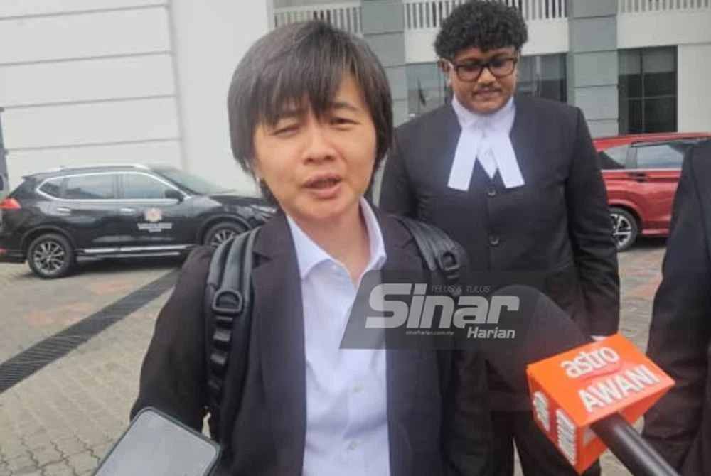 Joan (kiri) bersama rakan sepasukannya ketika ditemui pemberita di pekarangan Kompleks Mahkamah Kota Kinabalu.