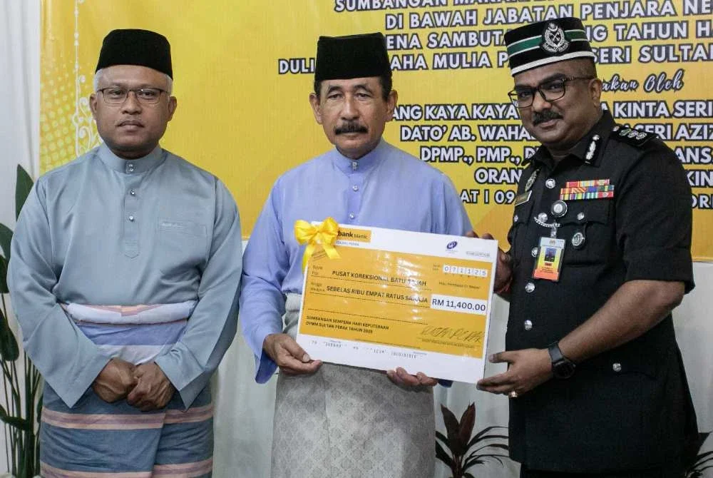 Ab Wahab (tengah) menyampaikan replika cek kepada Tanabal (kanan) pada Majlis Penyerahan Sumbangan Makanan dan Minuman Kepada Prospek sempena Sambutan Ulang Tahun Keputeraan ke-69 Sultan Perak pada Jumaat. Foto Bernama