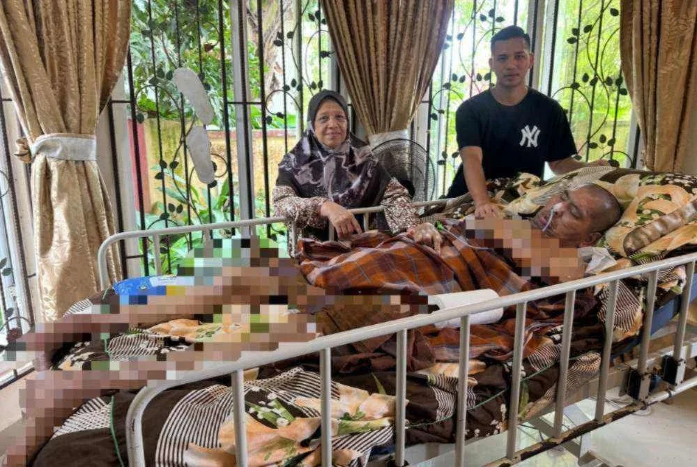 Fatimah (kiri) dan Muhammad Alif Haikal (kanan) bersama-sama menjaga Anuar.