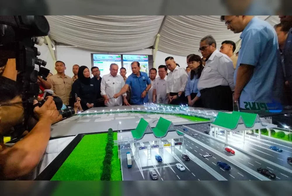 Anwar (tengah) mendengar taklimat mengenai pelaksanaan projek penyuraian Lebuhraya Bertingkat Sungai Dua-Juru.