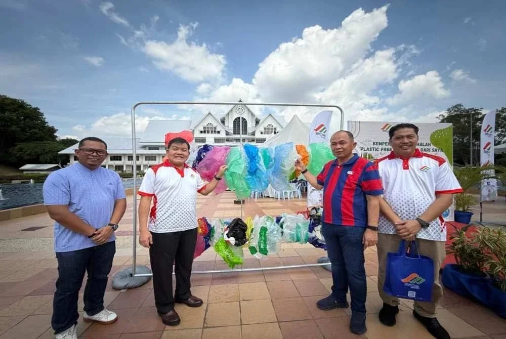 Loy Sian (dua dari kiri) meninjau beg plastik yang masih digunakan selepas merasmikan Kempen Jangan Gunalah: Bebas Plastik Bermula Dengan Saya di Melaka pada Sabtu.