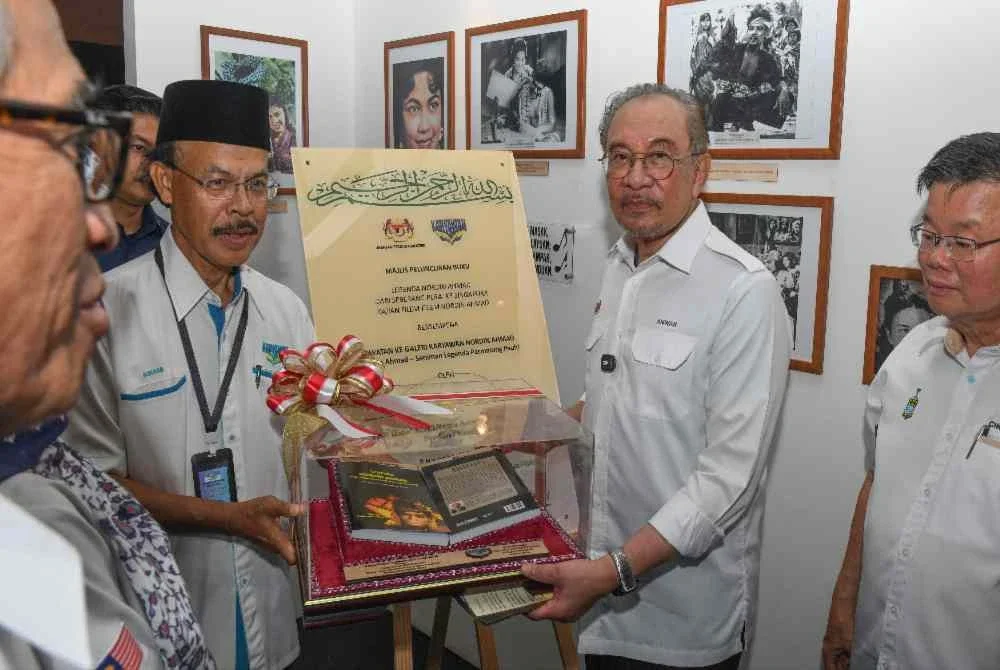 Anwar menerima buku legenda Nordin Ahmad daripada Pengerusi Persatuan Karyawan Pulau Pinang Datuk Dr Sohaimi Abdul Azizi pada majlis peluncuran buku itu di Galeri Karyawan Nordin Ahmad di SK Permatang Pasir, pada Sabtu. Foto Bernama 