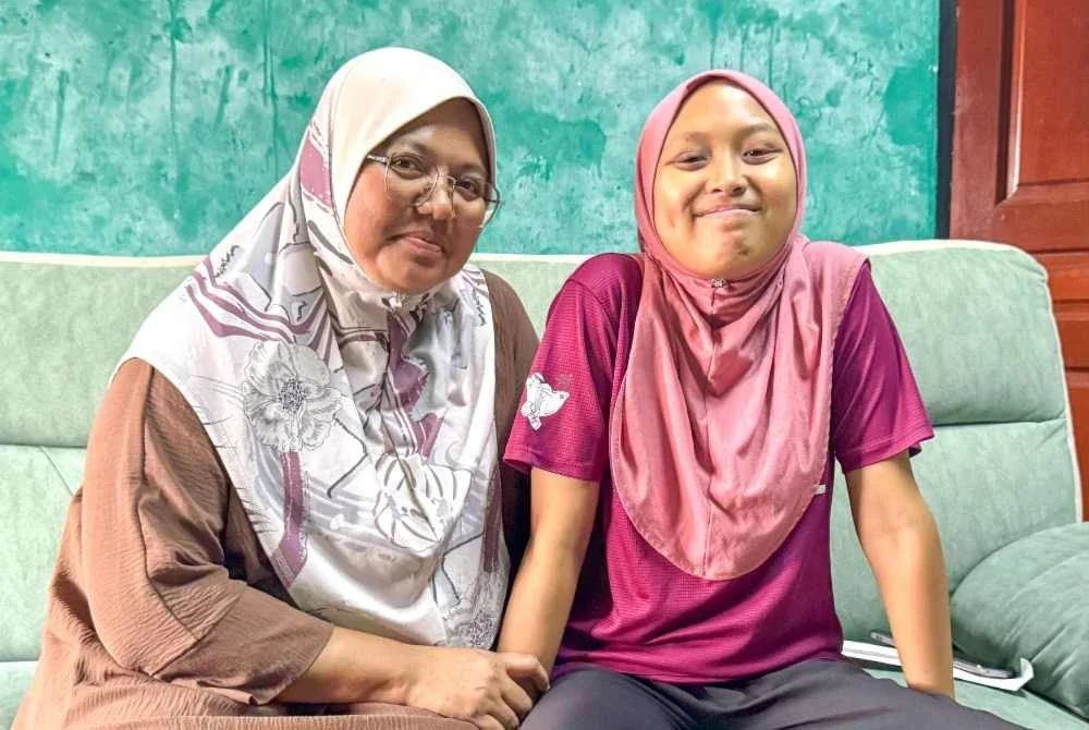 Noraslinda bersama anaknya, Nur Aimi yang menghidap leukemia.