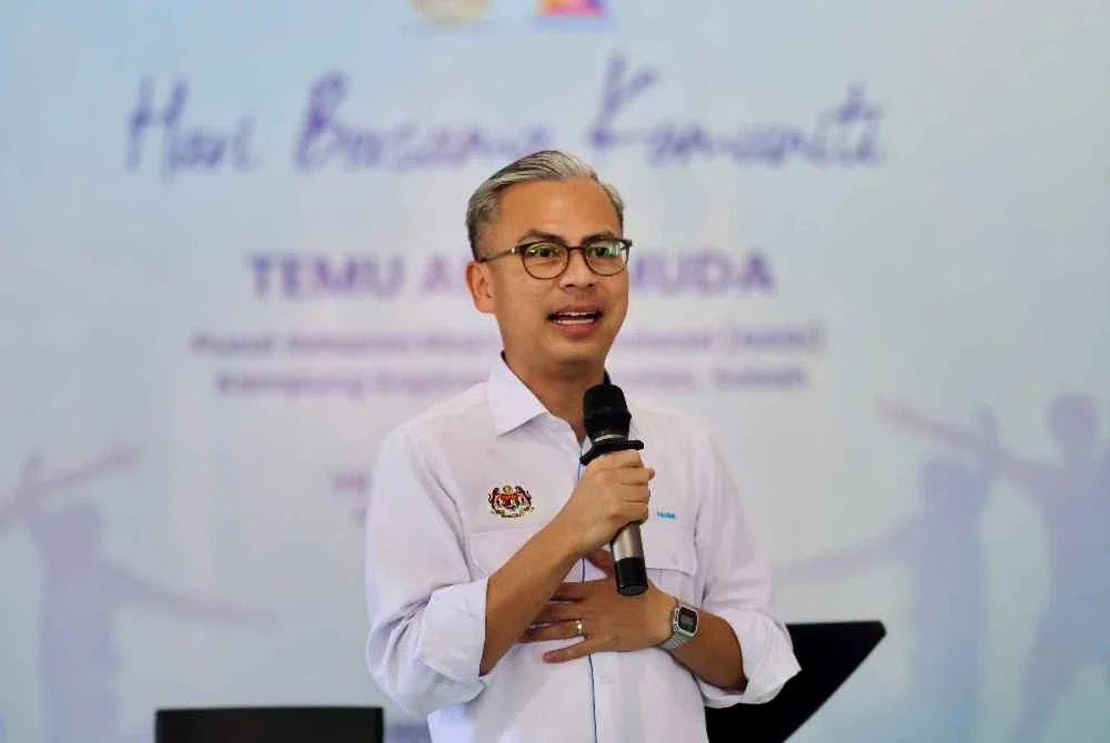 Fahmi menyampaikan ucapan dan menjawab soalan anak muda pada program Hari Bersama Komuniti dan Temu Anak Muda di Nadi Kampung Kopimpinan, Putatan pada Sabtu. Foto Bernama