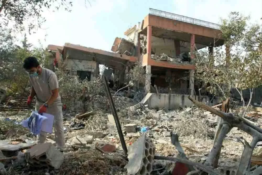 Seorang lelaki memeriksa kawasan yang musnah akibat serangan udara Israel pada malam sebelumnya di kampung Kfar Dounine, selatan Lubnan. Foto AFP