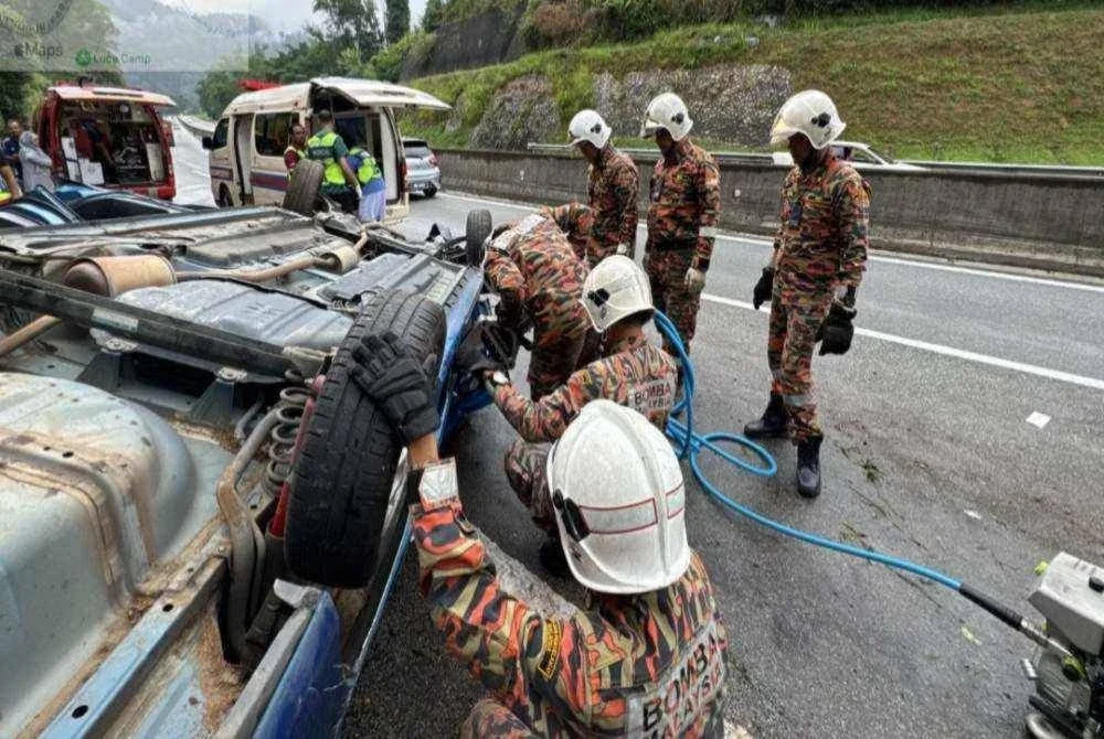 Anggota bomba membantu mengeluarkan mangsa yang tersepit di dalam kereta yang terbalik di Kilometer 44.2 Lebuhraya Kuala Lumpur- Karak (KLK) dekat Genting Sempah, Bentong pada Ahad. FOTO JBPM PAHANG