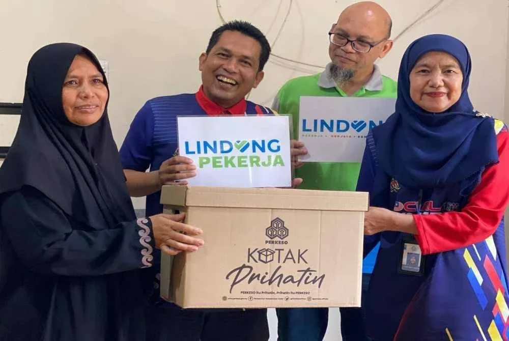 Nora (kanan) menyerahkan sumbangan FPM dan pencen penakat Perkeso kepada Hasliza di rumahnya Kampung Nibong Lemal, Pasir Mas pada Ahad. - Foto: SINAR HARIAN/HAZELEN LIANA KAMARUDIN