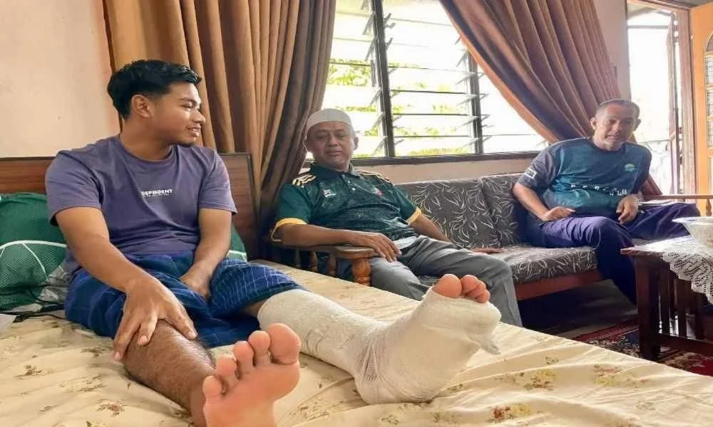 Ridzuan (tengah) menziarahi Muhammad Irfan di kediamannya di Kampung Tanjung Sabtu. FOTO: Facebook Ridzuan Hashim. 