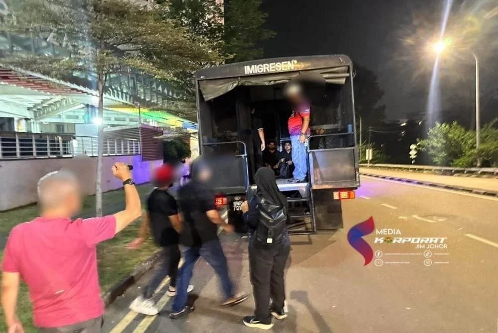 Warga asing yang ditahan dibawa menaiki trak ke depot tahanan. - foto JIM Johor