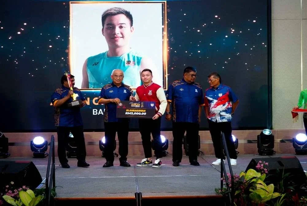 Ali Rustam (dua kiri) menyampaikan hadiah kepada Aaron yang dinobatkan Olahragawan Melaka 2023/2024 pada Majlis Anugerah Sukan Negeri Melaka ke-39 pada Isnin. FOTO: BERNAMA