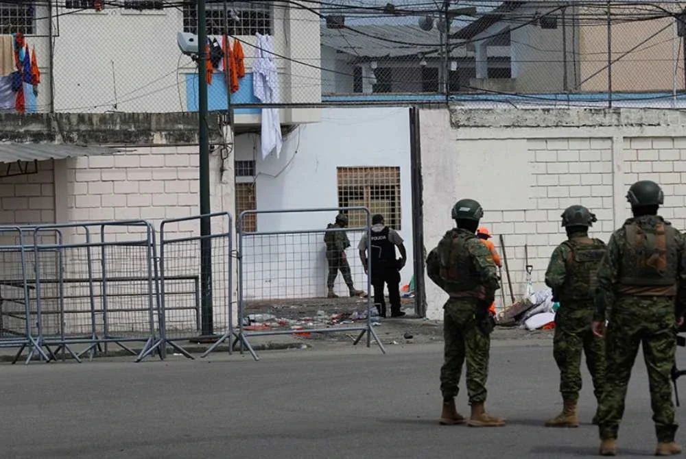 Anggota tentera mengawal kawasan di luar penjara di Machala, Ecuador, tempat banduan terbunuh dalam pertempuran sesama mereka. Foto AP