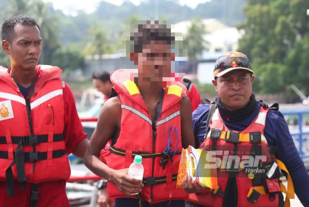 Ali (tengah) diselamatkan anggota bomba pada Selasa.