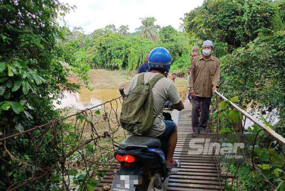 Jambatan usang ini menjadi laluan utama penduduk berulang-alik ke kebun.