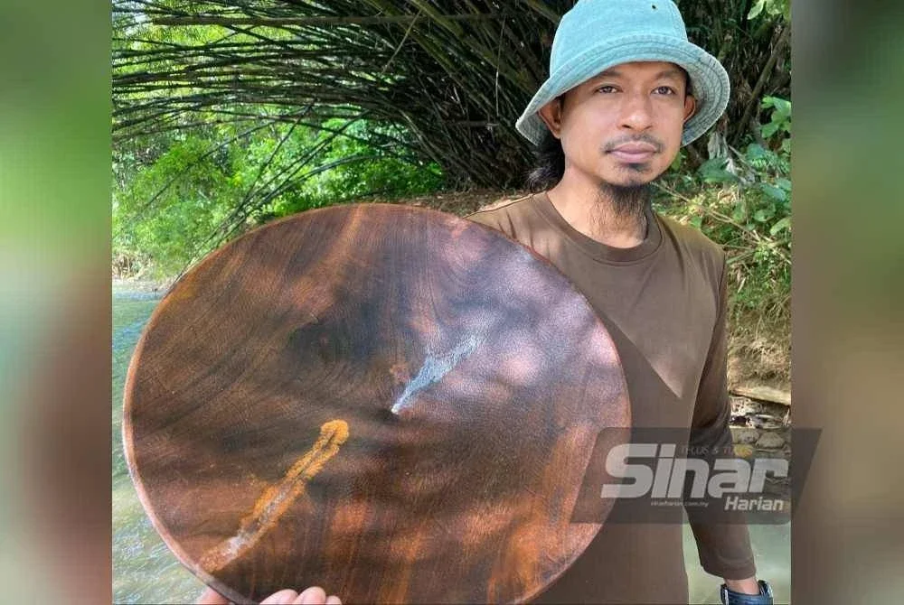 Kamil menunjukkan hasil emas yang diperoleh hasil mendulang di Sungai Tadoh, Jeli.