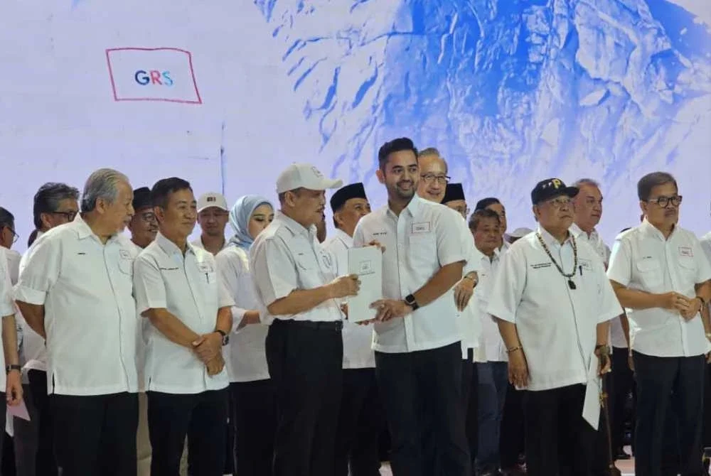 Shah Alfie ketika menerima watikah daripada Hajiji semasa majlis pengumuman calon GRS di SICC, Kota Kinabalu