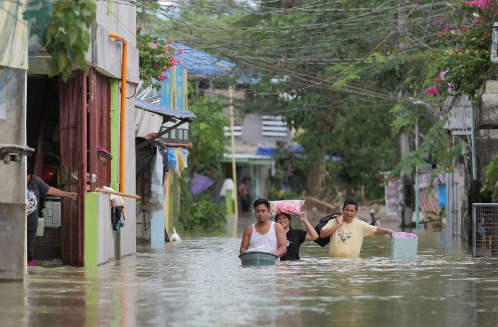 Antara mangsa dibawa ke tempat selamat selepas kawasan di Manila dilanda Taufan Uwan. Foto AFP